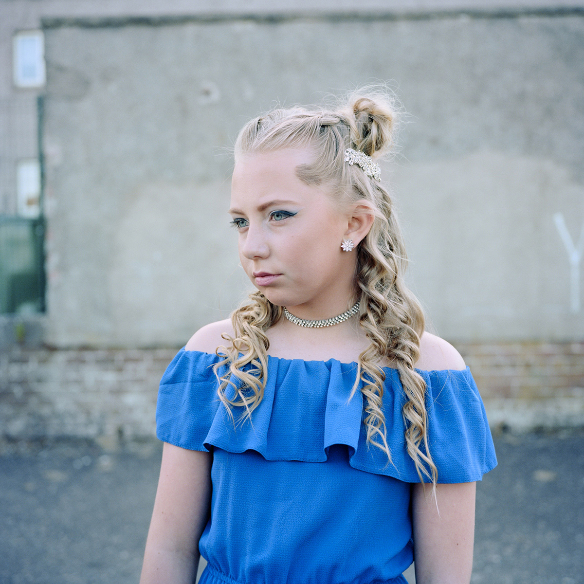 Photograph of a young girl with pagent style makeup and jewellery.