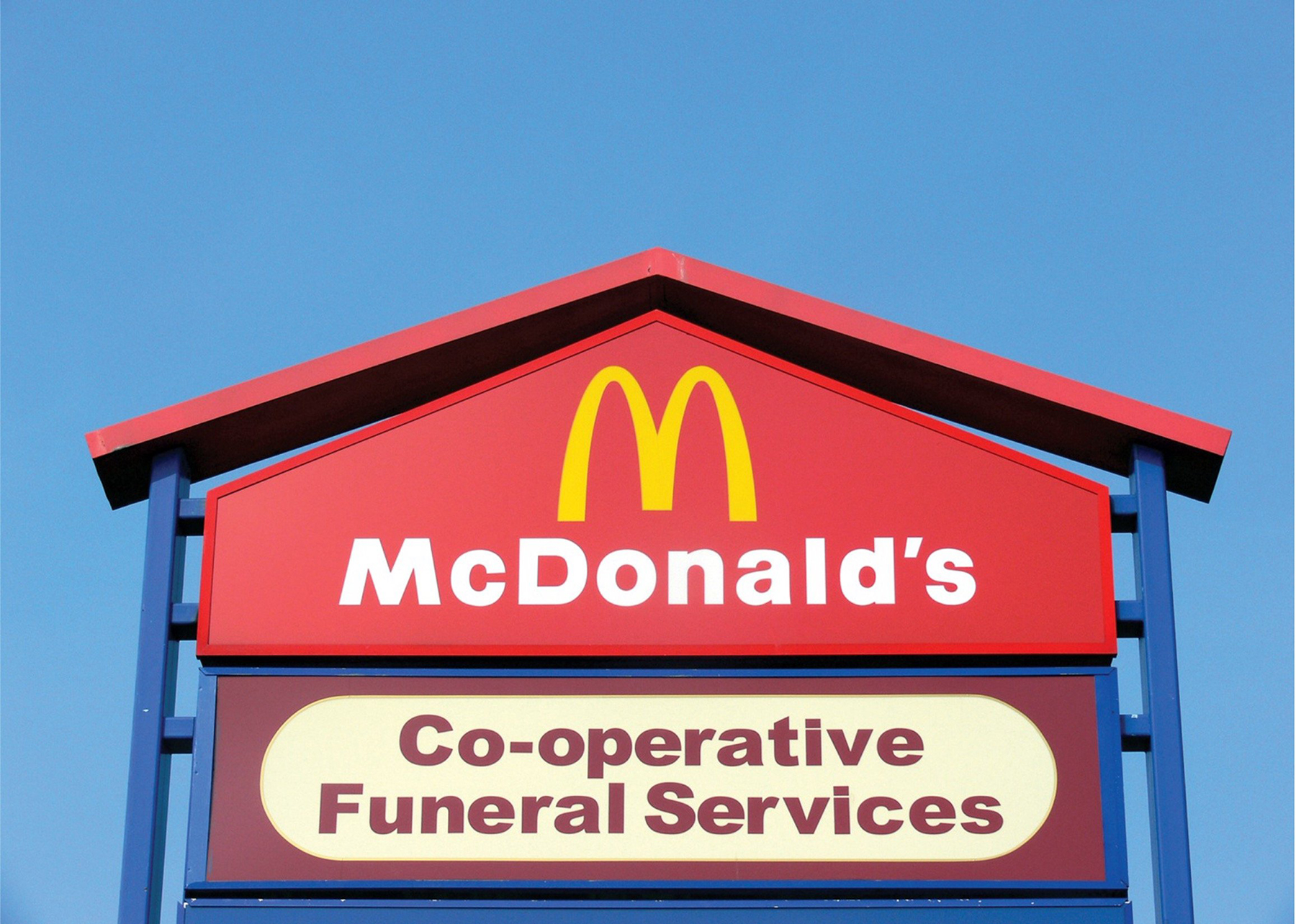 Photograph of retail park signage showing the McDonalds logo above the Co-operative Funeral Services logo.